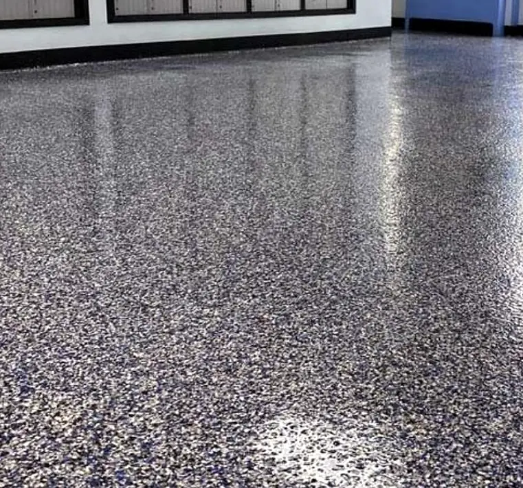 Blue, gray and white flake epoxy garage floor with a glossy clear coat reflecting the wall and windows