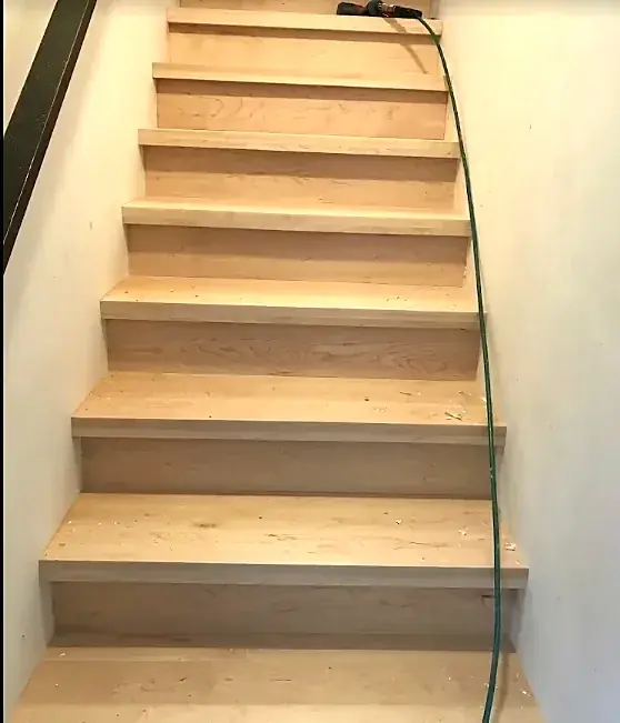 A straight stair with oak treads and oak risers between white walls